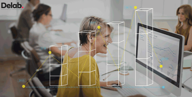 Uma mulher sentada em frente a um computador com gráficos de subida representados na tela